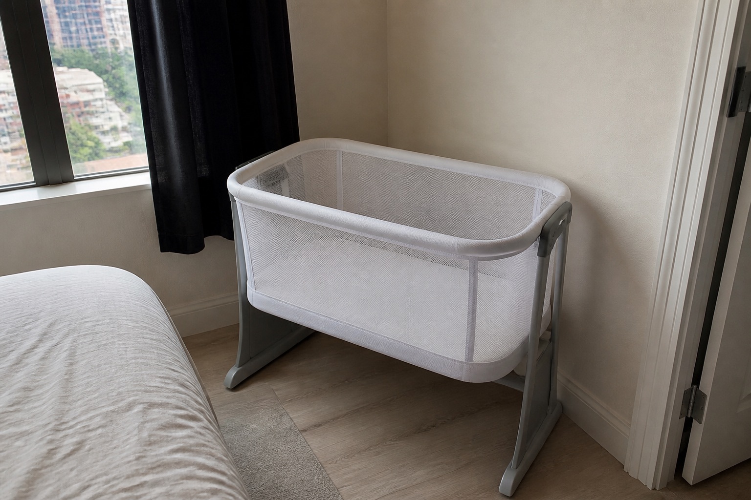 Empty white bassinet with a fitted sheet only